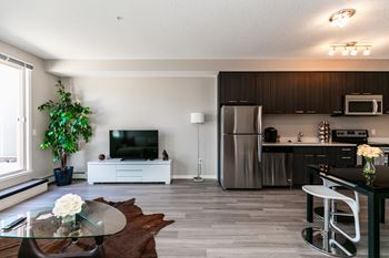 A modern kitchen with a refrigerator, microwave, and oven.